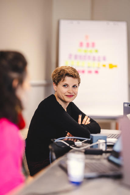 Portrait of Wiebke Hungrichhaußen, Head of Brand Studio, smiling confidently at her desk